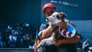Performance handler holding lovingly his border collie Australian shepherd mix at a festival with a Hero bottom swirl performance frisbee disc